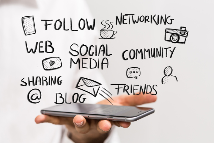 close up of a person holding a smartphone with social media illustrations hovering above for a social media spotlight fundraiser