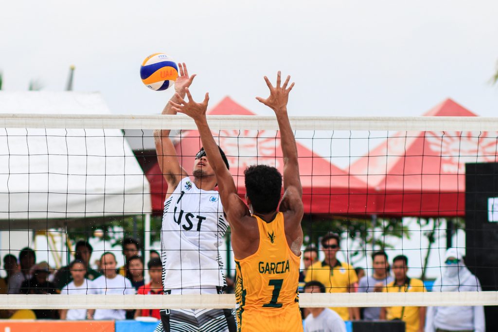 Adult males playing beach volleyball