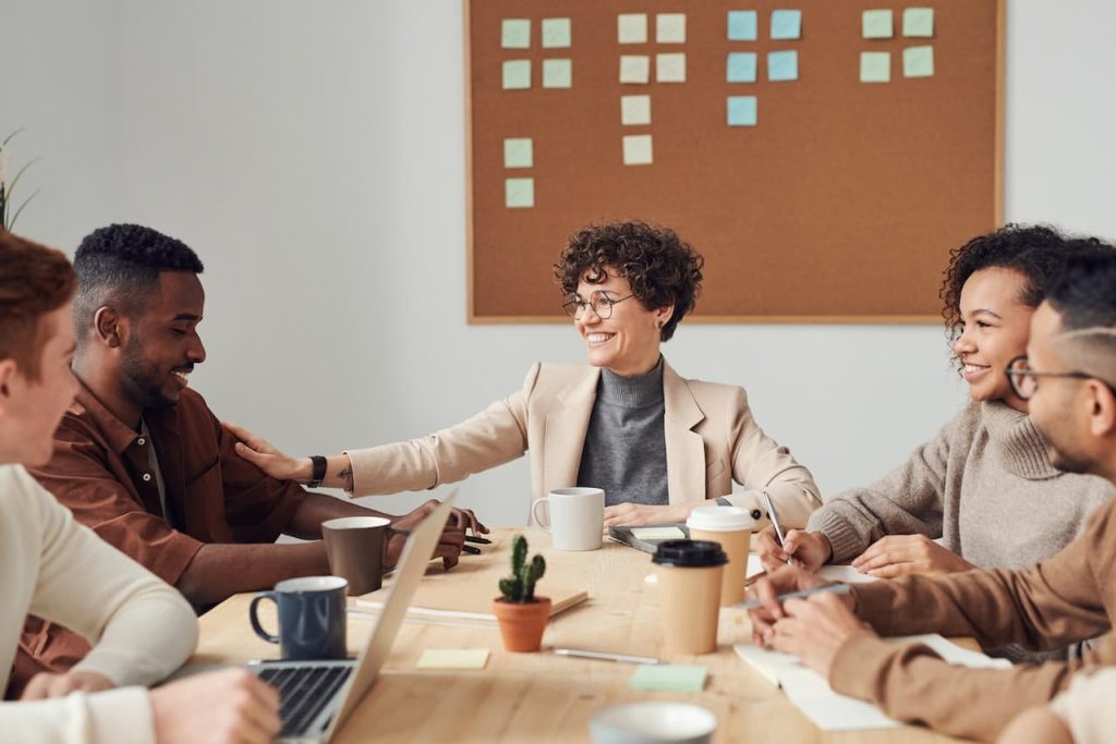 employees of a nonprofit that prioritizes diversity, equity and inclusion sitting at a conference table smiling